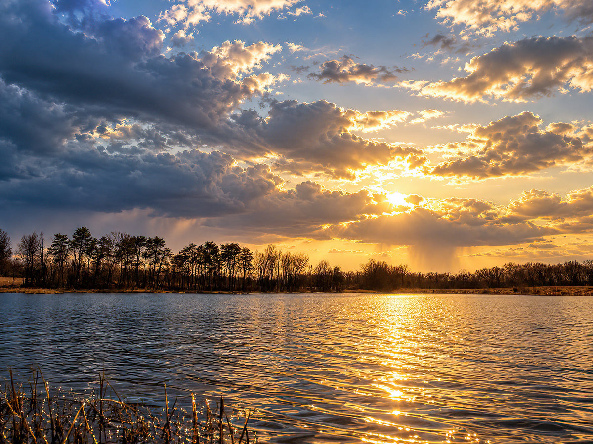 Wide Busch lake beneath clearing storm clouds with gold light reflected across the water